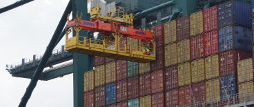 image of crane and stacks of shipping containers being loaded for transport