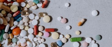 image of spilled pills and capsules on a gray background