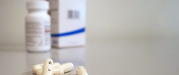 picture of white capsules with pill bottle and box in background