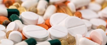 closeup of white, orange and green pills, capsules