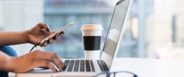 image of hands with phone, laptop, coffee and glasses