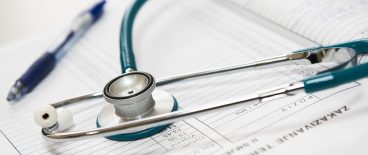 stethescope and pen on paper records