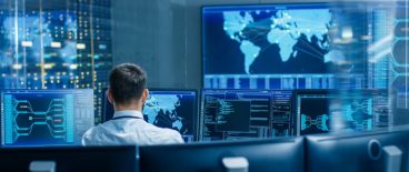 Back View in the System Control Center Operator Working. Multiple Screens Showing Technical Data