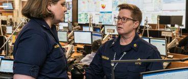 two women government workers talking in large control room