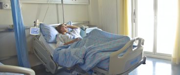Image of woman laying in hospital bed in recovery room