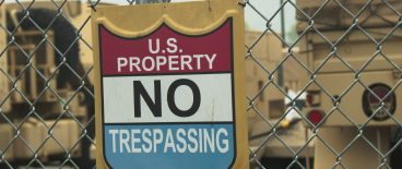sign on chain link fence saying U.S. Property Not Trespassing
