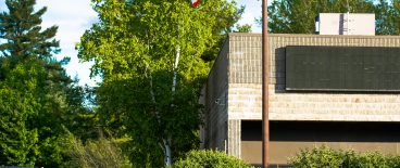 image of American flag on flagpole in front of non-descript government building