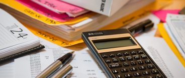 image of income tax book, files, diary, calculator and pen on a table