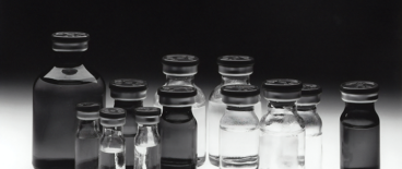 lack and white photo of glass bottles filled with liquid