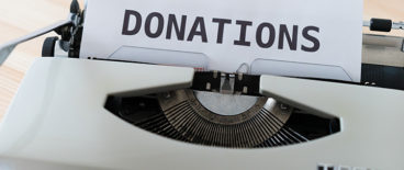 typing machine with a paper with a word donation slid into it