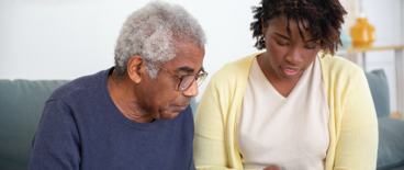 nurse reading to an elderly man