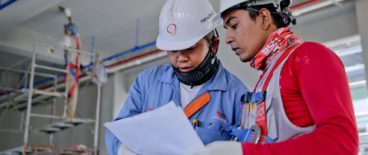 two construction workers looking at papers