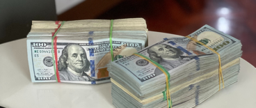 hundred dollar bills tied with rubber bands