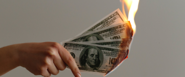 a person holding a money on fire