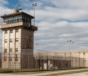 a prison watchtower with a barbed wire fence around it 
