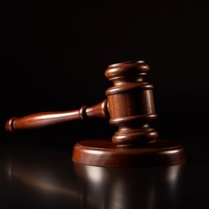 a wooden judge's gavel against a black background