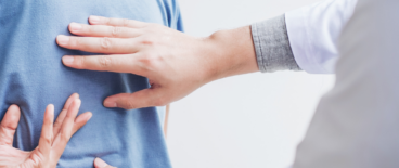 doctor checking on a patient with back pain