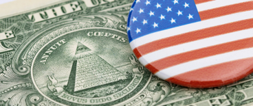 American flag badge on top of a one dollar bill