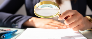 a woman reading a document with a looking glass