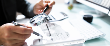 a person reading documents with a looking glass