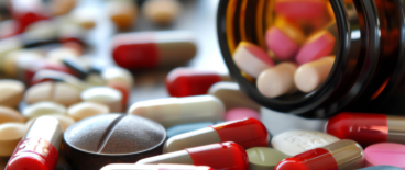 a bunch of spilled medicine tablets in various shapes and colors, scattered together